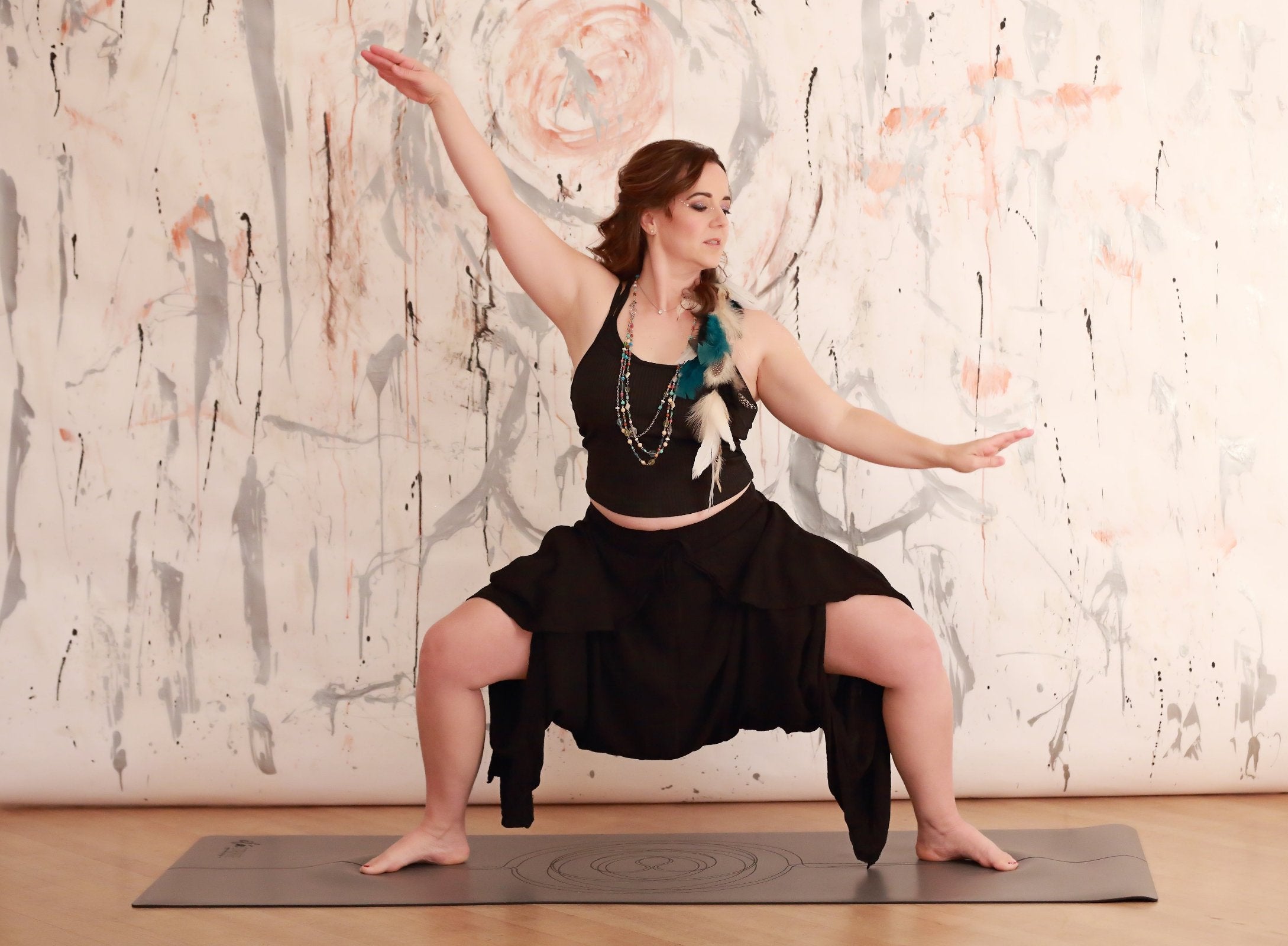 beautiful yoga instructor in goddess pose using a grippy pro mat. yoga mat features an organic sacred geometry design on engraved grip top rubber yoga mat