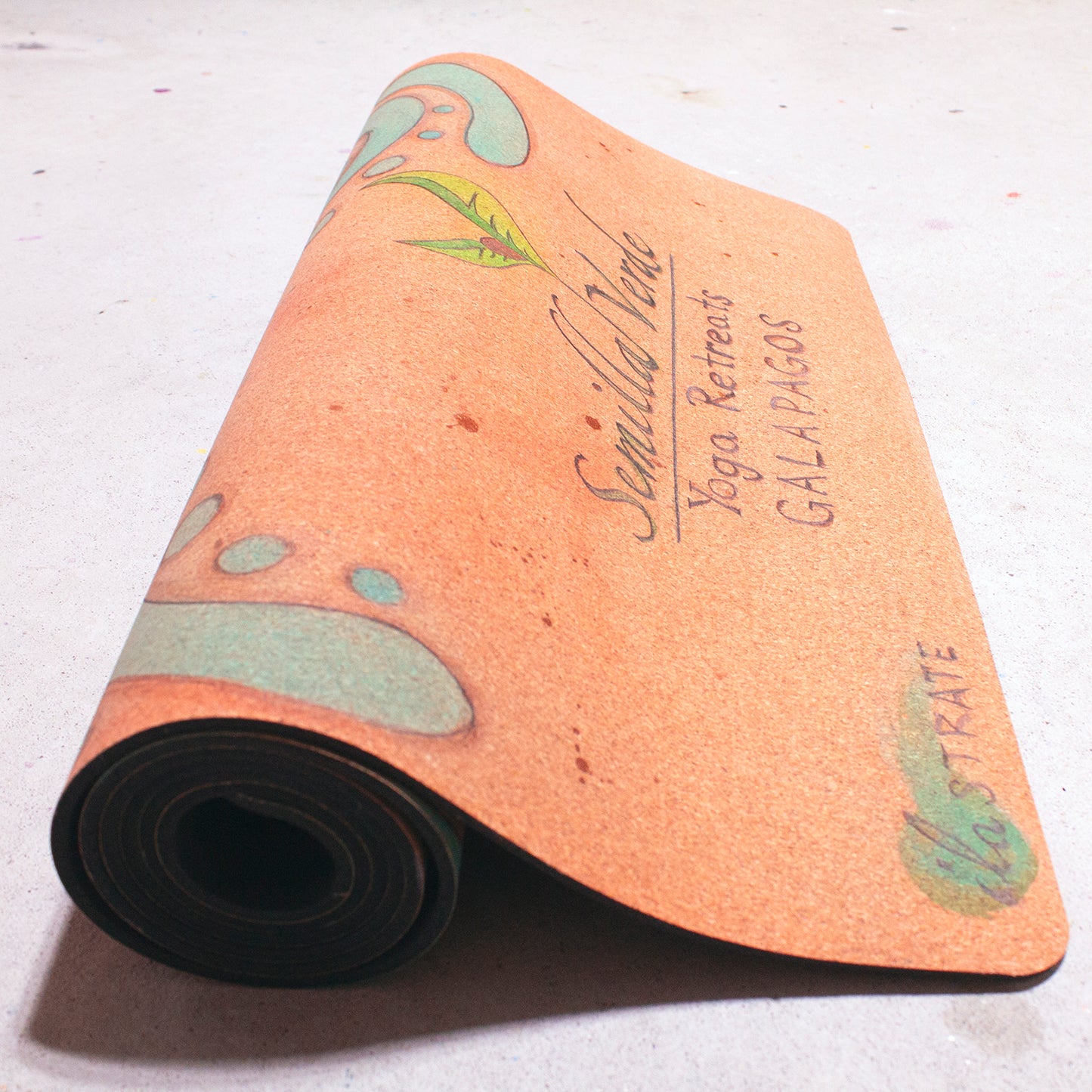 rolled cork yoga mat with semilla verde galapagos yoga retreats logo