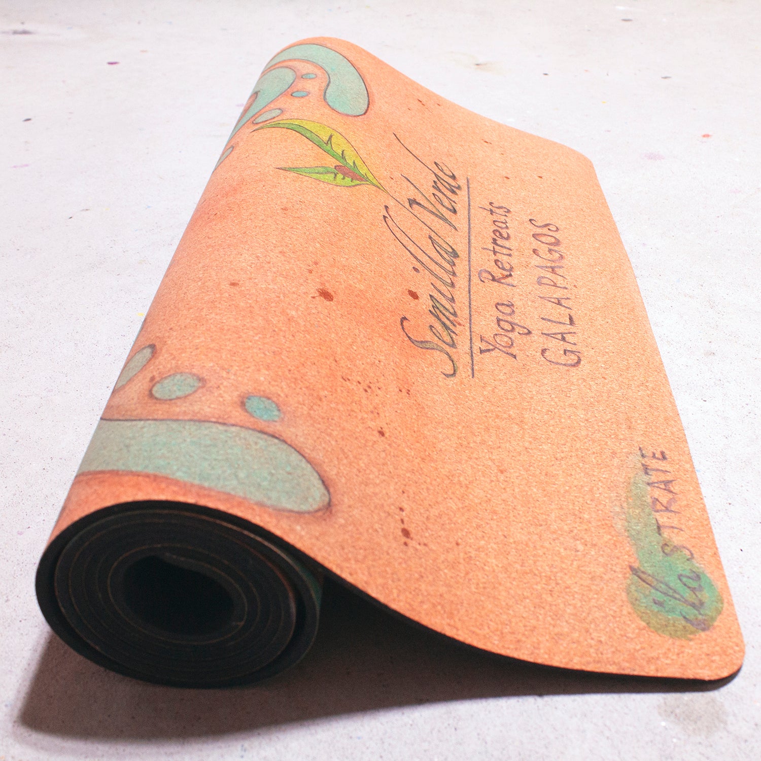 rolled cork yoga mat with semilla verde galapagos yoga retreats logo
