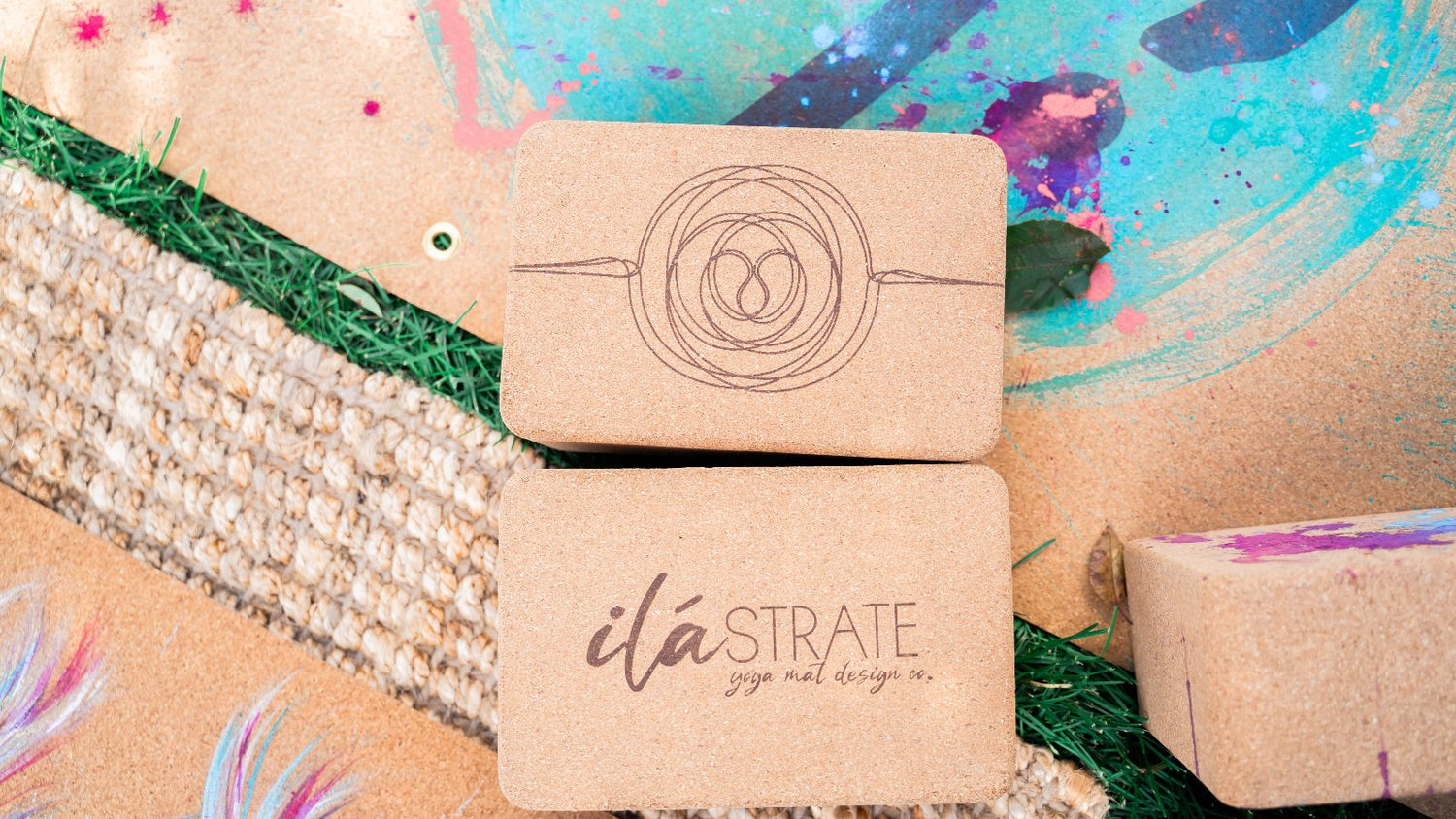 ilaSTRATE cork yoga blocks on a background of hand painted ilaSTRATE cork yoga mats.