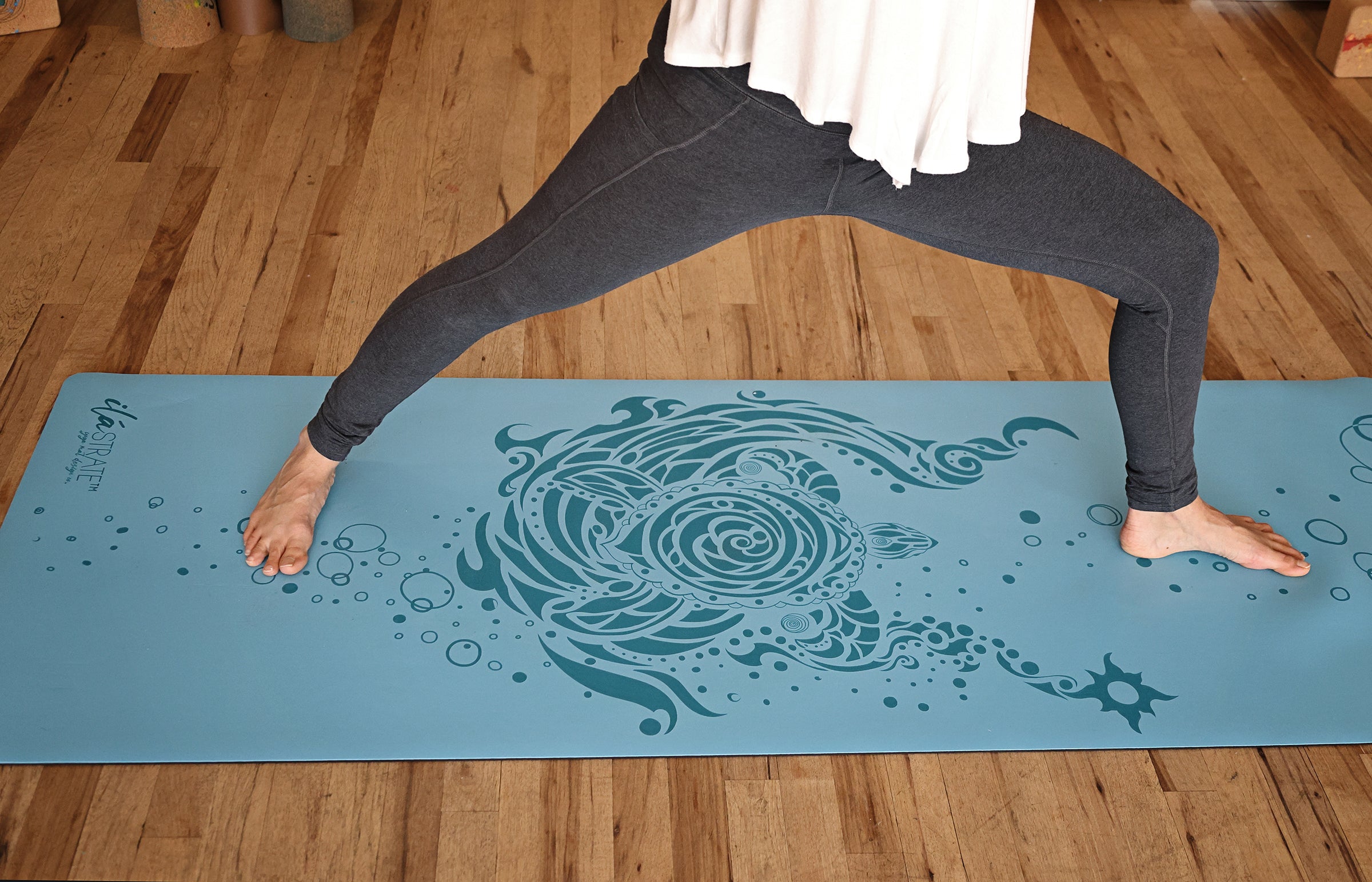 model posing on aqua blue pro yoga mat with turtle design sold by ilastrate yoga mat deisgn company